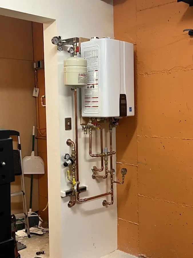 Plumbing technician inspecting water heater connections in River Rouge